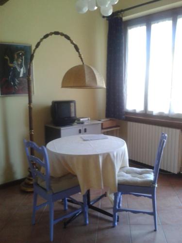 Habitación con una mesa con sillas y una lámpara. en Agriturismo Casa Re, en Santa Maria della Versa