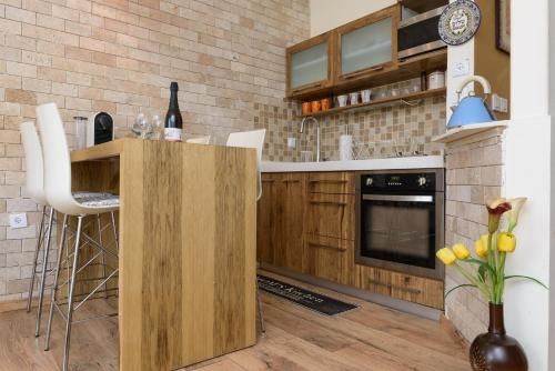 a kitchen with wooden cabinets and a counter top at Sunset TLV Apartment - Ben Yehuda 175 in Tel Aviv