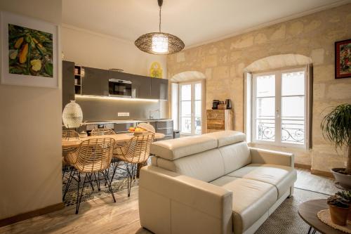 a living room with a white couch and a table at Nona Home Bordeaux in Bordeaux