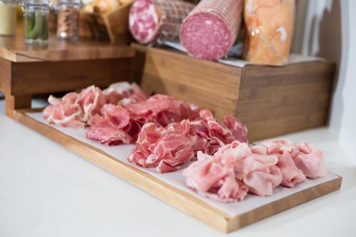 a bunch of cuts of meat on a cutting board at Lancaster Bangkok in Bangkok