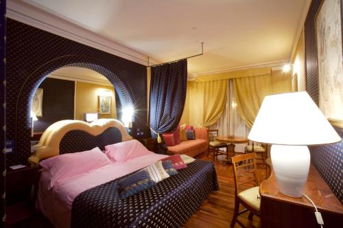 a bedroom with a bed and a lamp and a couch at Hotel Tosco Romagnolo in Bagno di Romagna