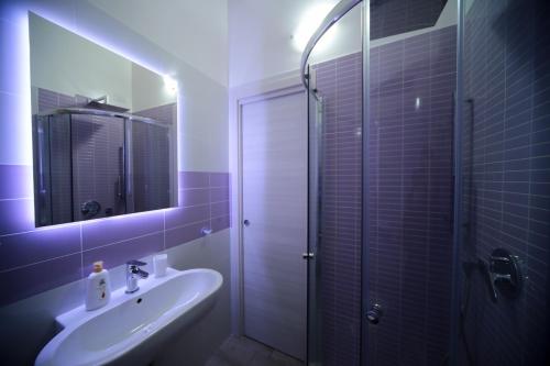bagno con lavandino e doccia con specchio di Suite delle Rondini Apartment ad Alghero