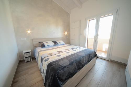 una camera con un grande letto e una grande finestra di Suite delle Rondini Apartment ad Alghero
