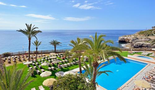 a view of a resort with a pool and the ocean at Alua Calas de Mallorca Resort in Calas de Mallorca