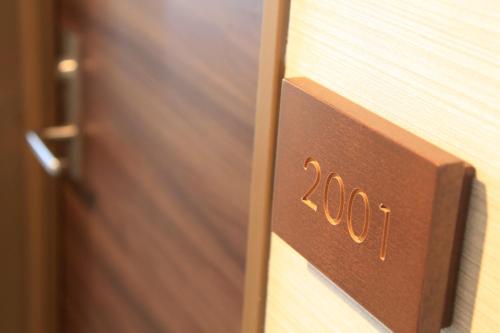 a wooden door with the number on it at Shonandai Daiichi Hotel Fujisawa Yokohama in Fujisawa