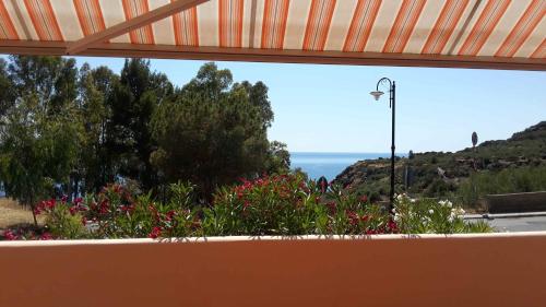 a window with a view of flowers and the ocean at Casa del Geco in Rinella