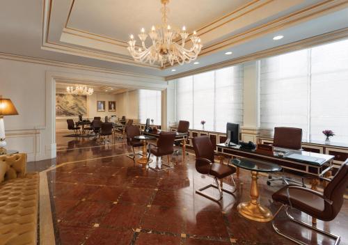 a conference room with chairs and tables and a chandelier at Grand Regency Doha, Trademark Collection by Wyndham in Doha