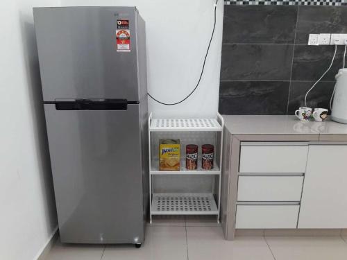a silver refrigerator in a kitchen next to a counter at OOI Homestay Alor Setar in Alor Setar