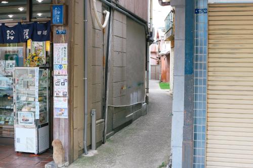 an alley with signs on the side of a building at the CUE in Tanabe