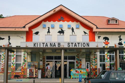 a building with a sign that reads kittima b station at the CUE in Tanabe