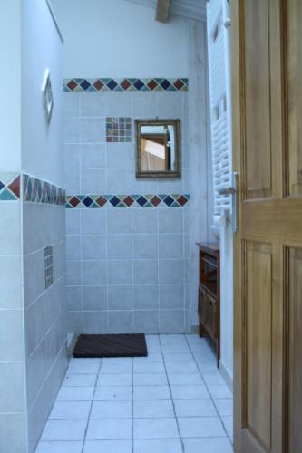 a bathroom with a tub and a tile floor at Le Patio in Parentignat
