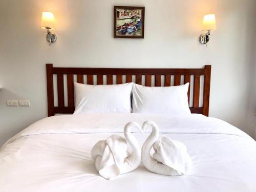 two swans sitting on top of a bed at Baan Chang Residence in Bang Sare