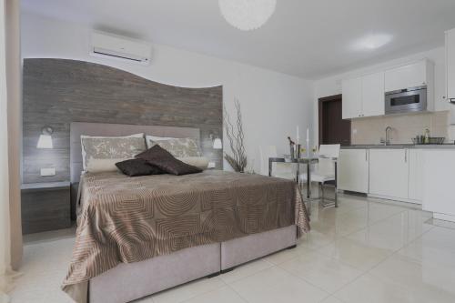 a bedroom with a large bed and a kitchen at Apartments Maritea in Vodice