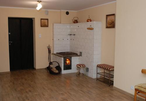 a living room with a brick fireplace with a stove at Apartamenty Sawino 4 in Tykocin
