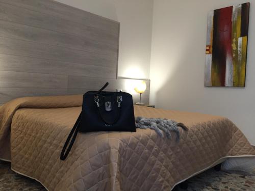 ヴェローナにあるPoloni Apartmentのベッドの上に座る黒い袋