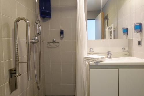 La salle de bains est pourvue d'une douche et d'un lavabo. dans l'établissement Hôtellerie Franciscaine, à Saint-Maurice