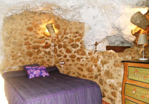 Bedmar的住宿－La Serrana，一间卧室设有石墙和床
