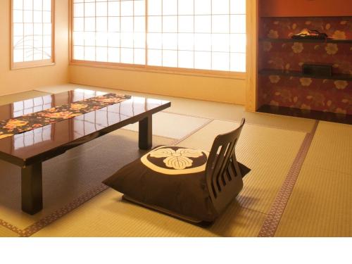 a room with a table and a chair in it at Matsui-Bekkan Hanakanzashi in Kyoto