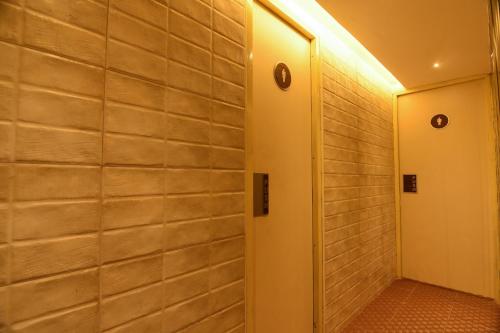 a hallway with a brick wall and a door at Roopa Elite in Mysore