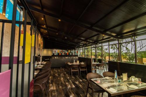 a dining room with tables and chairs and windows at Roopa Elite in Mysore
