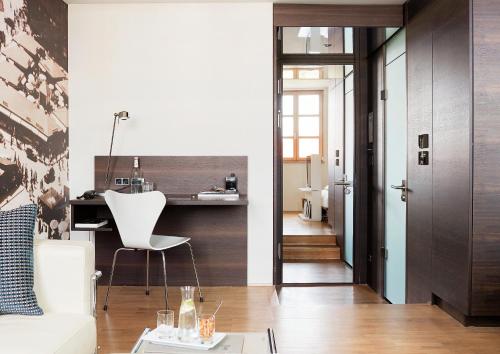 a living room with a white chair and a table at Living Hotel Das Viktualienmarkt in Munich
