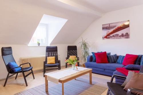 a living room with a blue couch and chairs at Apartment Breite Str. 83 in Witten