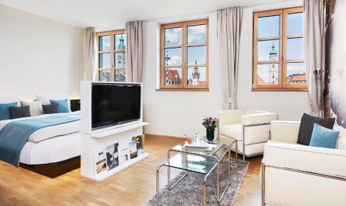 a living room filled with furniture and a tv at Living Hotel Das Viktualienmarkt in Munich