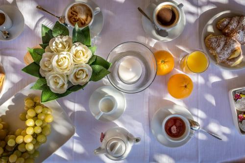 a table with food and cups of coffee and flowers at Hotel Emma Small Luxury Hotel in Florence