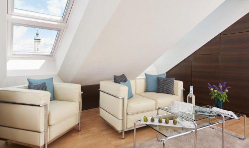 a living room with two chairs and a table at Living Hotel Das Viktualienmarkt in Munich