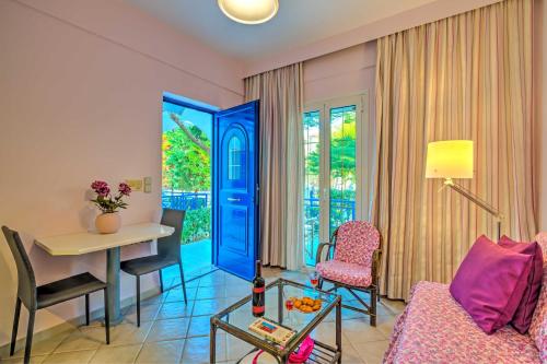 un soggiorno con porta blu, tavolo e sedie di Elegant 1BR by Heraklion Beach Sun &Comfort Await ad Amoudara Herakliou
