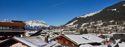 a town covered in snow with mountains in the background at KitzHome City Apartments in Kitzbühel