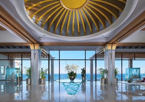 eine Lobby mit einer großen Decke und Glasfenstern in der Unterkunft Atrium Prestige Thalasso Spa Resort & Villas in Lachania