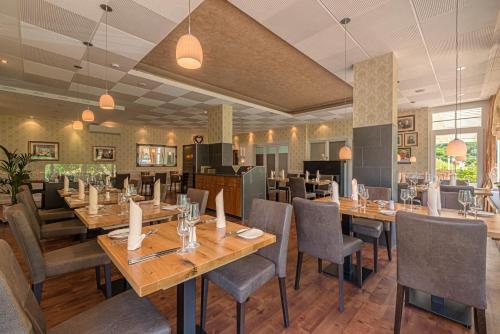 a dining room with wooden tables and chairs at Hotel Weinberg-Schlößchen in Oberheimbach