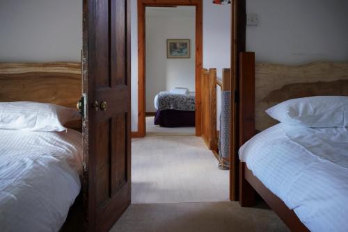 a bedroom with two beds and a door to a room at No3 Luib in Luib