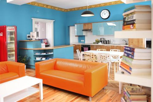 sala de estar con sofá naranja y cocina en Blooms Boutique Hostel, en Poznan