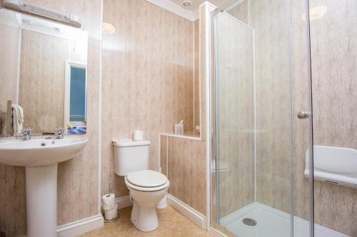 a bathroom with a shower and a toilet and a sink at The Queens Hotel in Penzance