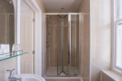 a shower with a glass door in a bathroom at The Queens Hotel in Penzance
