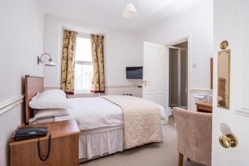 a hotel room with a bed and a desk at The Queens Hotel in Penzance