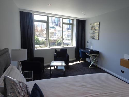 a hotel room with a bed and a desk and a window at PrivateStudio in Quay West Building in Melbourne