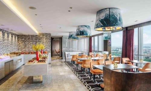 a restaurant with tables and chairs and windows at Hard Rock Hotel Shenzhen in Shenzhen