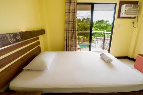 Un pat sau paturi într-o cameră la Greenfields Tourist Inn