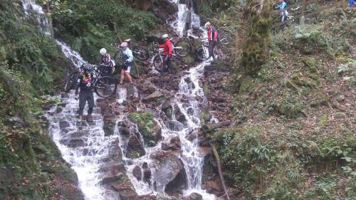 a group of people on bikes in front of a waterfall at Mendi Alai in Carranza