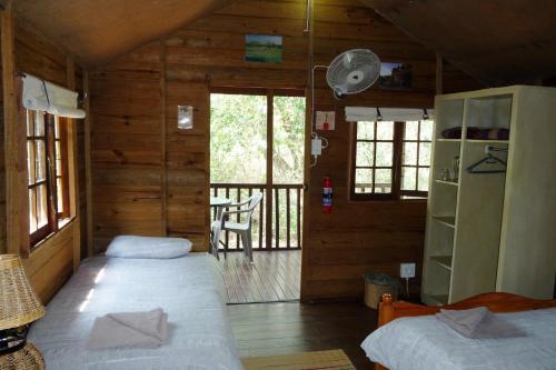 a bedroom with two beds in a wooden cabin at Isinkwe Bush Camp in Hluhluwe