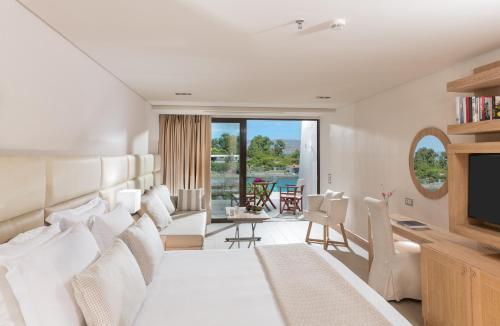 una habitación de hotel con una cama y un televisor en Elounda Bay Palace, a Member of the Leading Hotels of the World, en Elounda