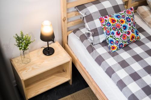 a small bedroom with a bed with a lamp on a table at HOSTEL "likeHOME" in Przemyśl