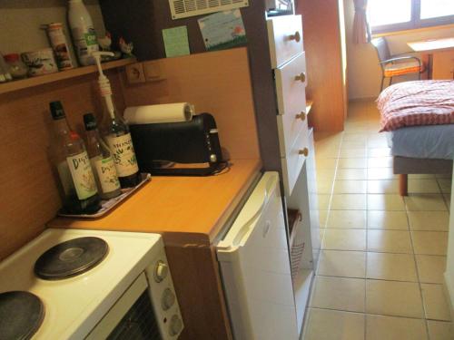 a kitchen with a counter with bottles of wine at Chambre d'Hôte ROMARICA in Saint-Sigismond