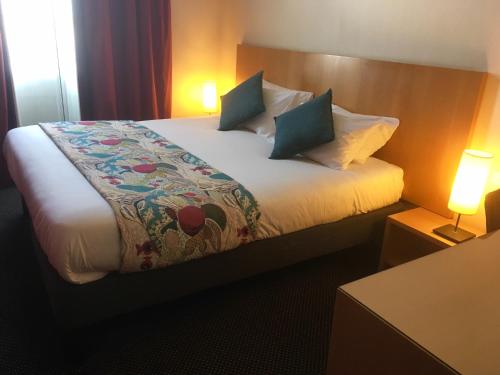 a hotel room with a bed with two pillows at Best Western Adagio Saumur in Saumur