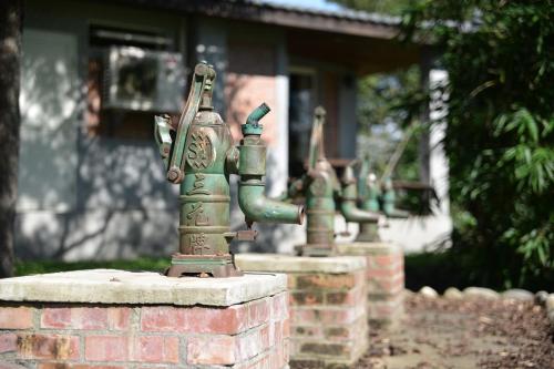 a group of green statues on a brick wall at Fangshuh B&B in Fenglin