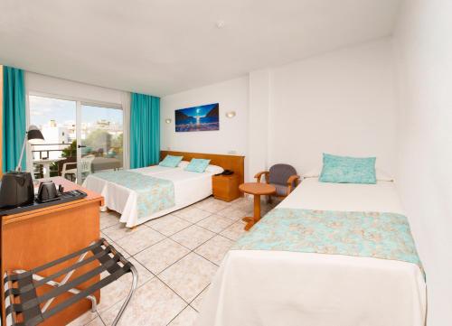 a hotel room with two beds and a balcony at Hotel Tropical in San Antonio