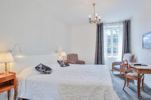 a bedroom with a bed and a table and chairs at Logis Hotel Royal Saint-Mart in Royat